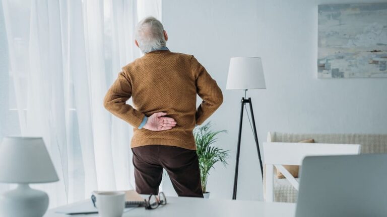 Idoso com dor nas costas, em virtude da hérnia de disco