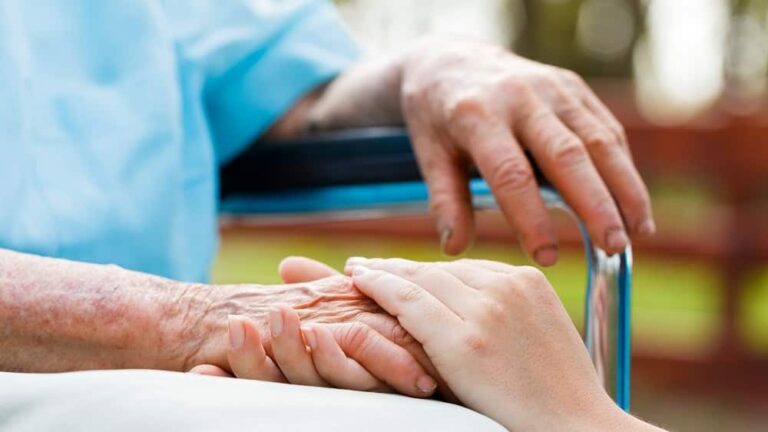 idoso sentando, de mãos dadas com jovem. Suicídio assistido ainda é tabu