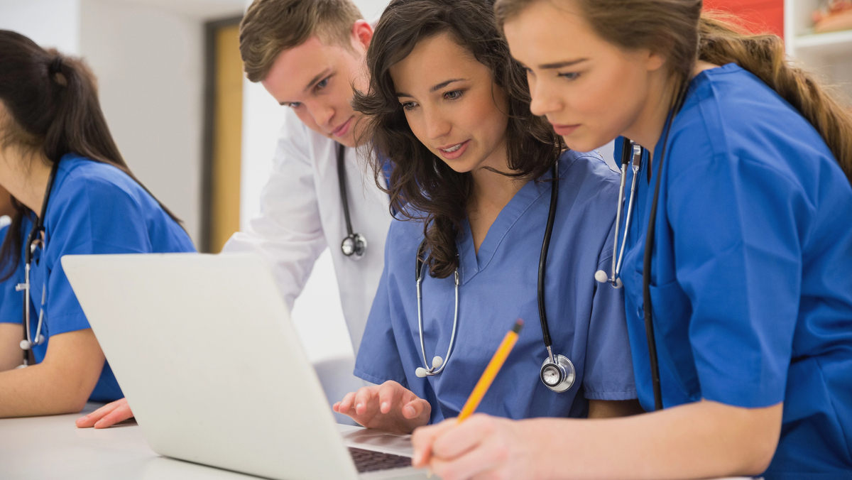 jovens olham computador em sala de aula de faculdade de medicina