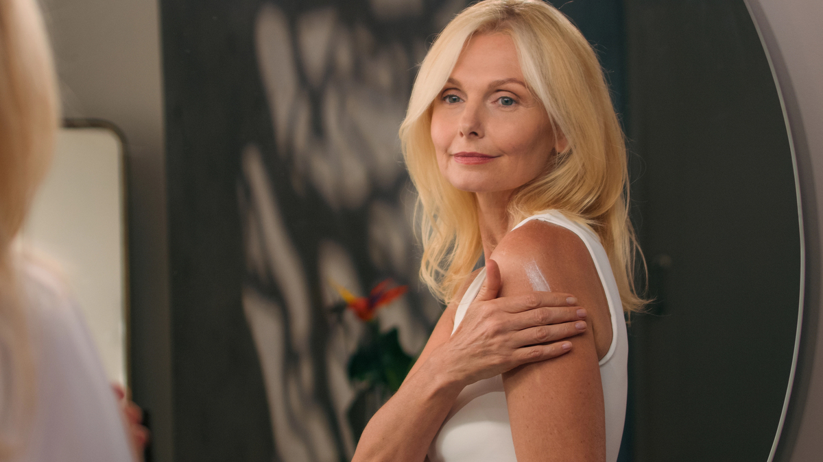 mulher mais velha aplicando gel de testosterona no braço