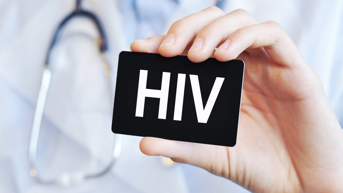 médico segurando placa onde se lê HIV