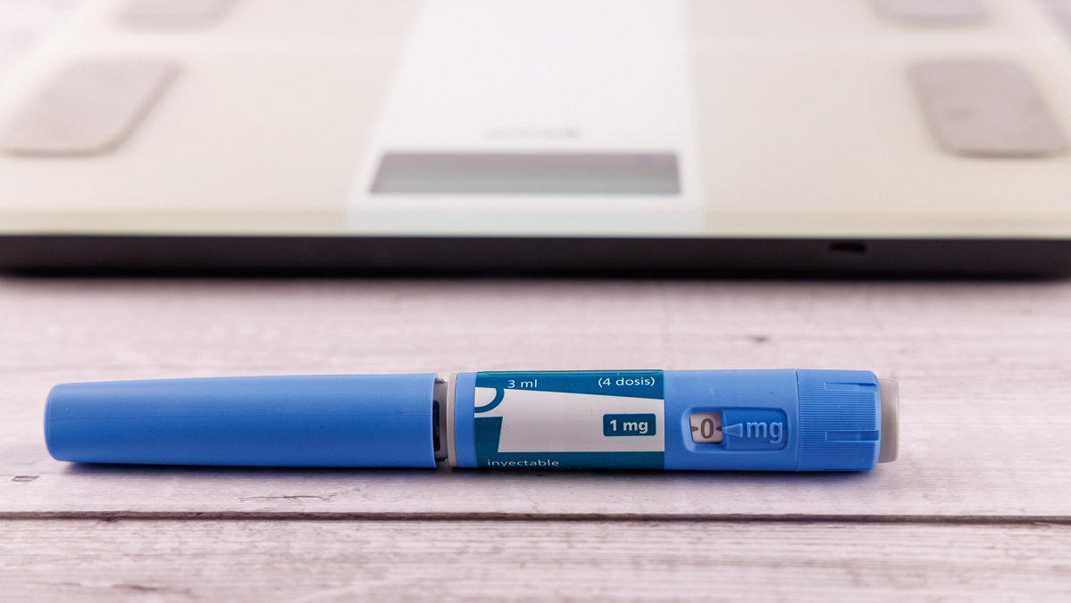 caneta de Ozempic sobre a mesa, com balança atrás
