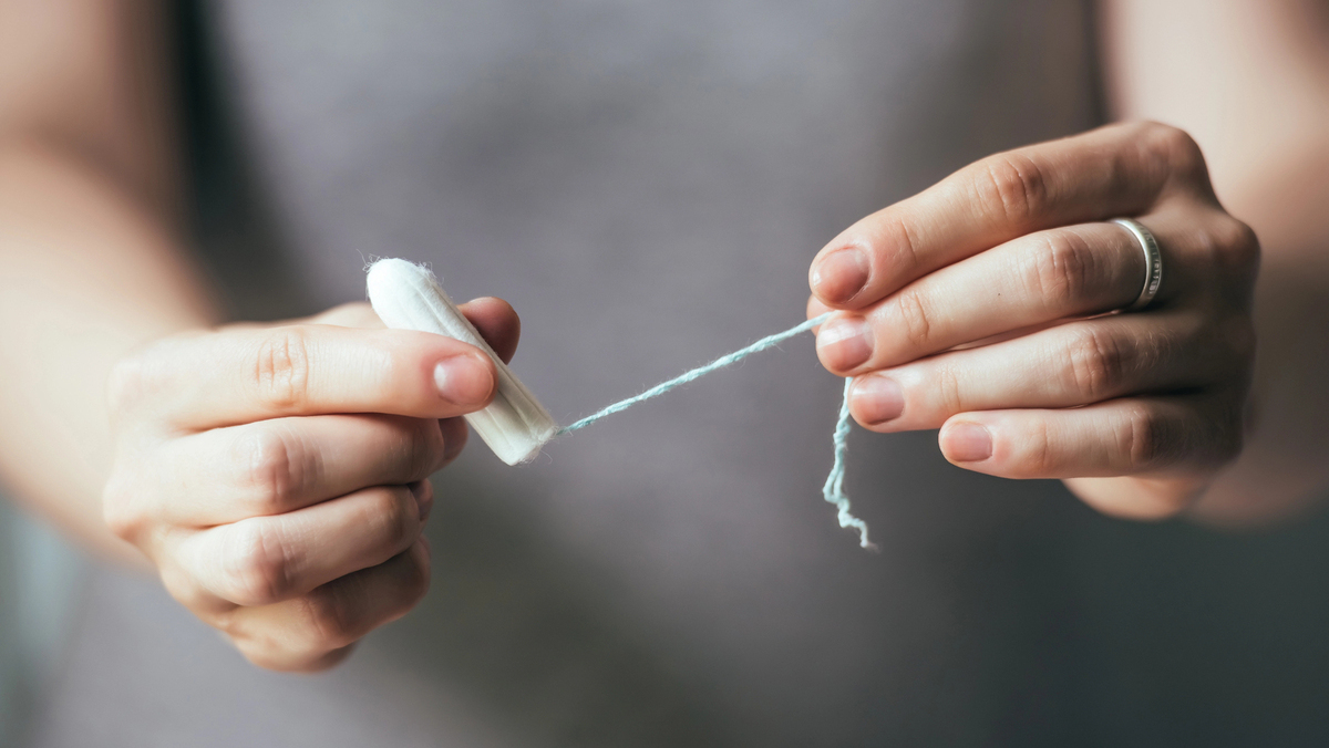 close em mãos de mulher segurando absorvente interno