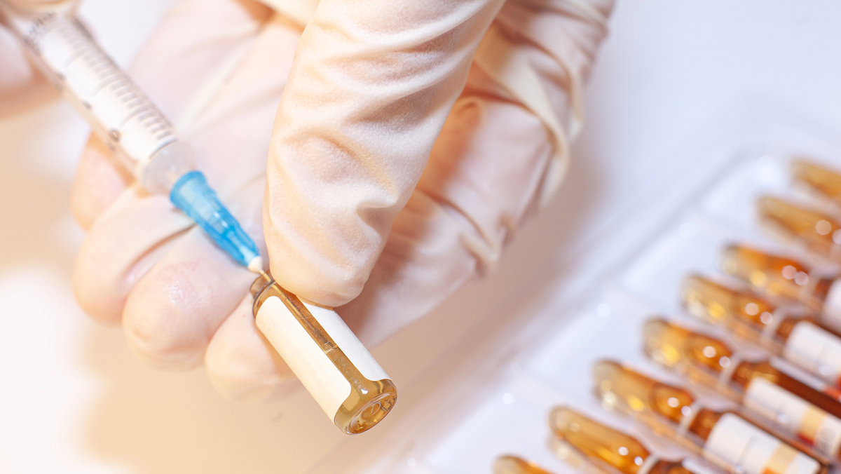 close em mão de médico preparando injeção de B12 para tratar anemia perniciosa