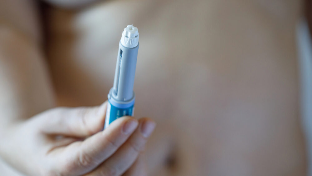 close em mão de mulher segurando caneta emagrecedora