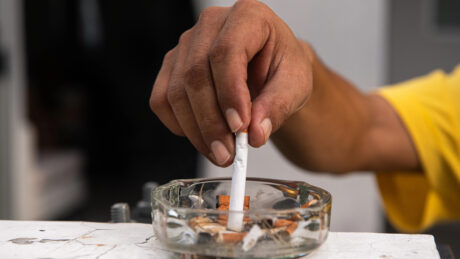 close em mão de homem apagando cigarro para evitar câncer