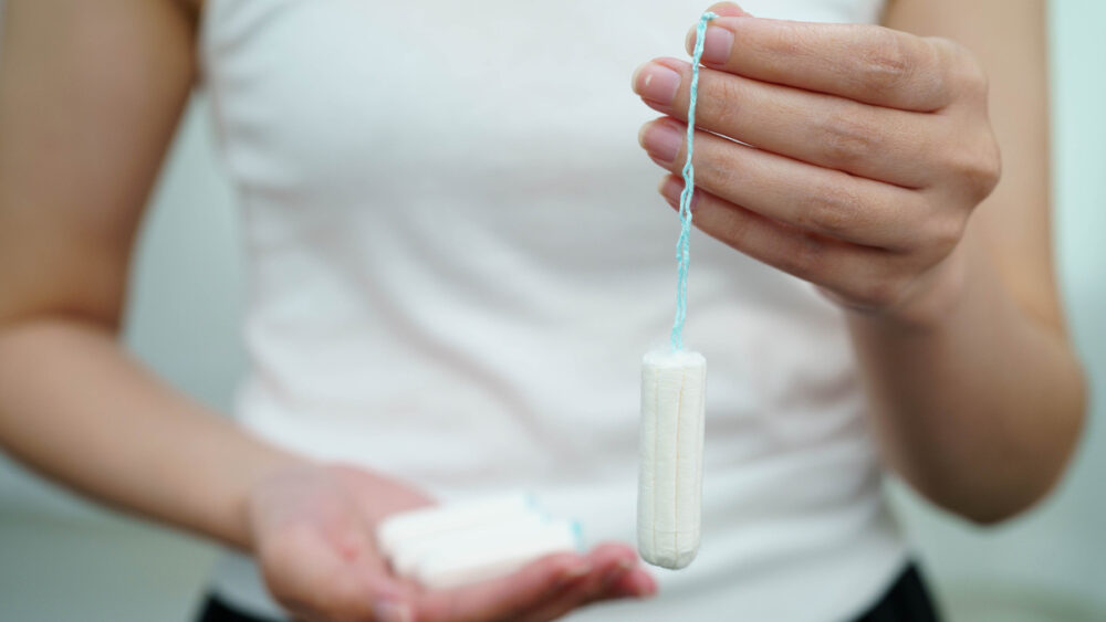 mulher com fluxo menstrual intenso segura absorvente interno